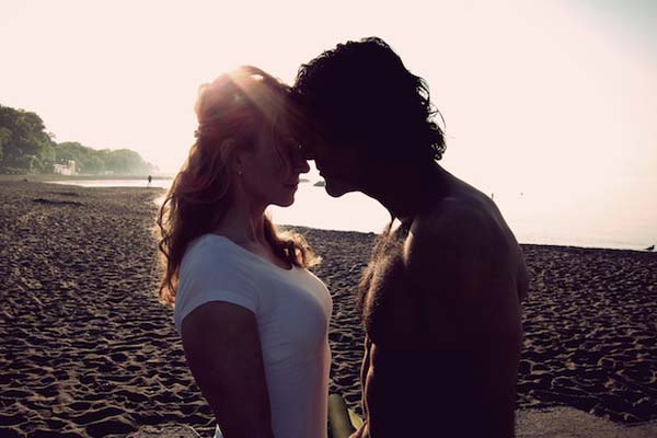 Couple starting passionately into one another's eyes on the beach